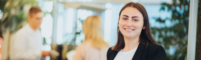 LBS NordWest Studentin steht im Büro am Schreibtisch